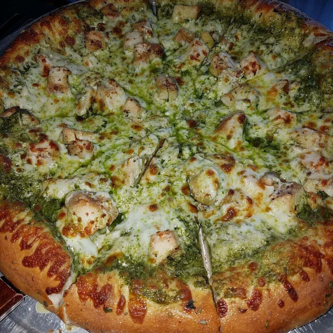 A pizza topped with broccoli and cheese on a wooden table.
